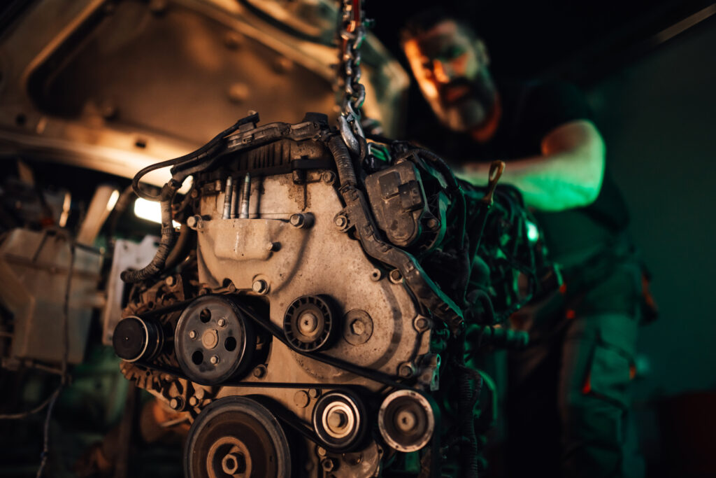 Auto mechanic installing engine